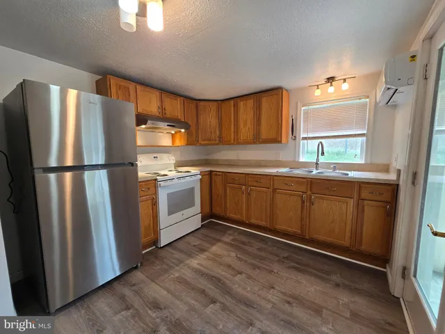 a kitchen with a refrigerator sink and cabinets