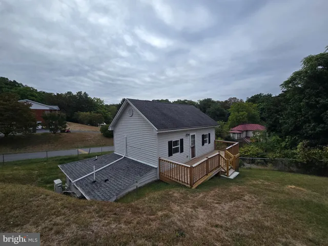 an aerial view of a house with a yard and trees in the background
