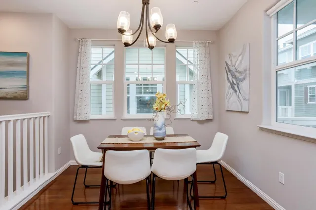 a dining room with furniture a chandelier and wooden floor