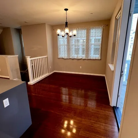 a view of a livingroom with wooden floor and staircase