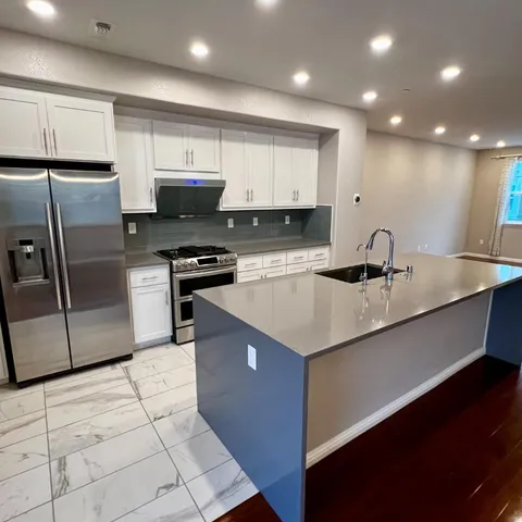 a kitchen with kitchen island a sink stainless steel appliances and cabinets