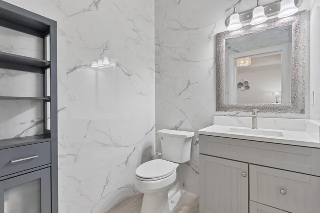 a bathroom with a toilet sink and mirror