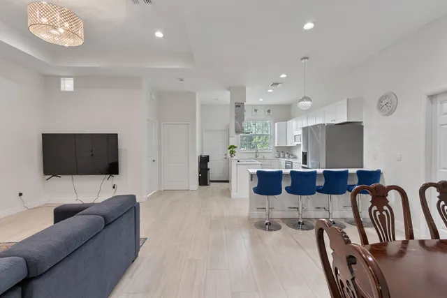 a living room with furniture a flat screen tv and kitchen view