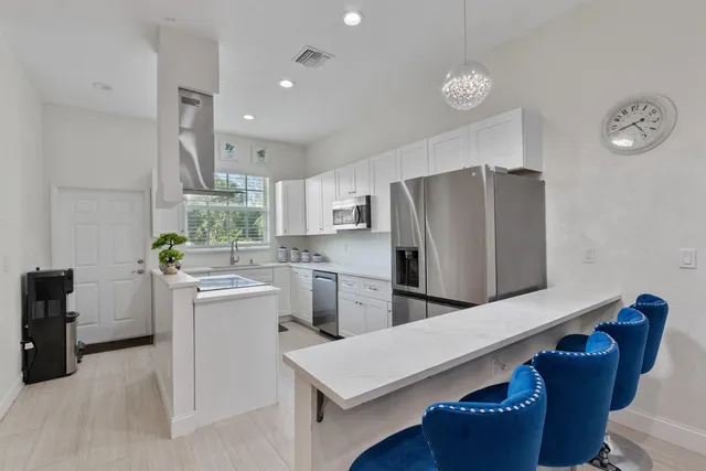 a kitchen that has a refrigerator a stove and a sink with wooden floor