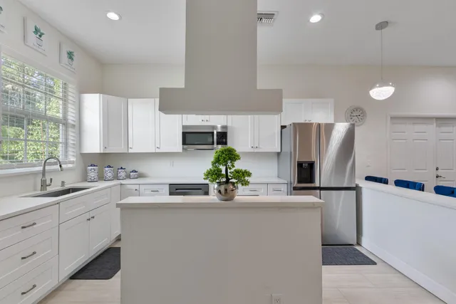 a kitchen with stainless steel appliances a sink cabinets and a window