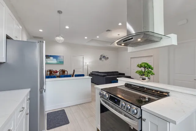 a kitchen with stainless steel appliances a stove a sink and a refrigerator