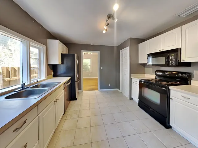 a large kitchen with stainless steel appliances granite countertop a sink and cabinets
