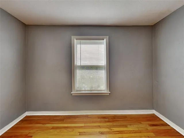 a view of a room with wooden floor and a window