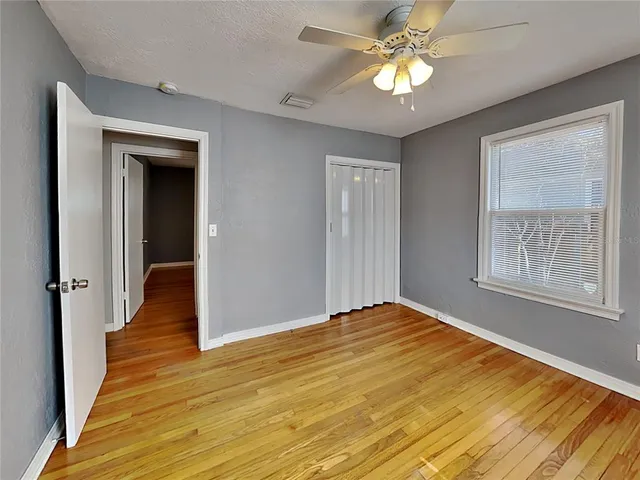 a view of empty room with wooden floor