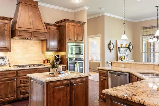 a kitchen with stainless steel appliances granite countertop a stove and a refrigerator
