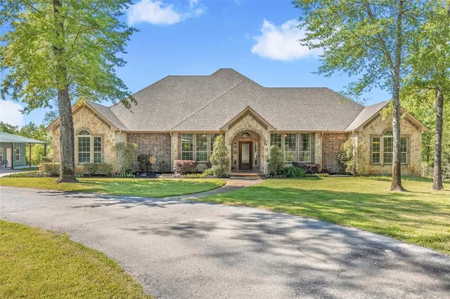 a front view of a house with a yard and trees