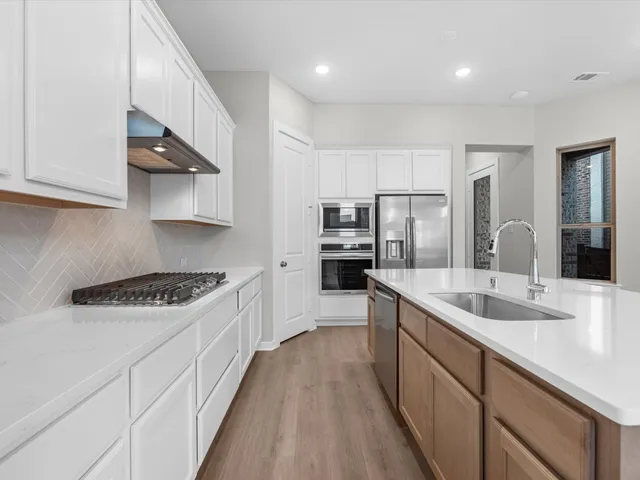 a kitchen with stainless steel appliances granite countertop a sink stove and refrigerator