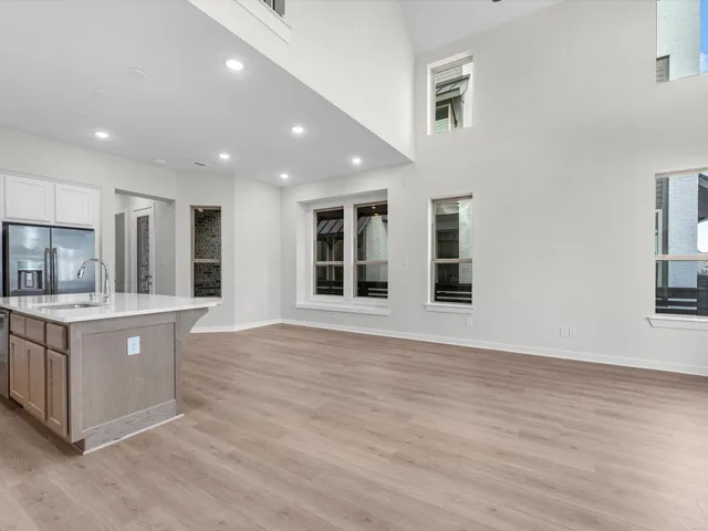 a large kitchen with stainless steel appliances granite countertop a large stove a refrigerator a sink and a dishwasher with wooden floor