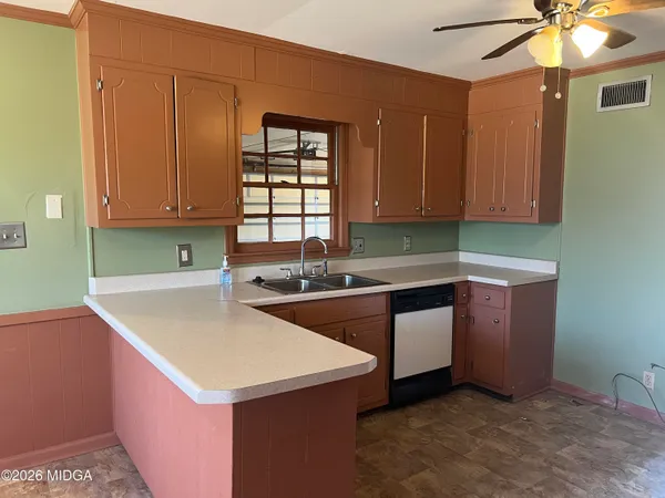 a kitchen with a sink cabinets and wooden floor