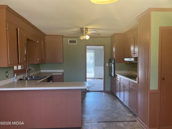 a kitchen with stainless steel appliances granite countertop a sink and dishwasher a refrigerator with wooden cabinets