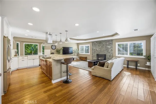 a kitchen with kitchen island granite countertop wooden floors and white cabinets
