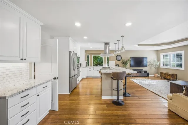 a kitchen with a stove and a wooden floor