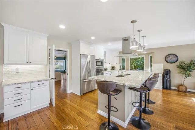 a kitchen with stainless steel appliances granite countertop a stove a sink and a refrigerator