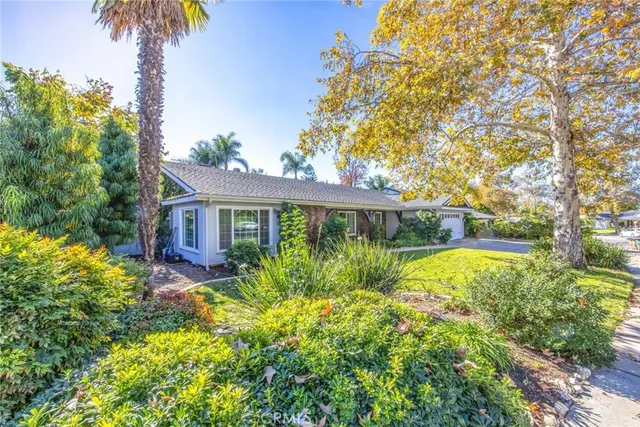 a front view of a house with a yard and potted plants