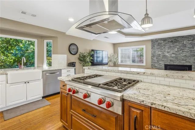 a living room with furniture and kitchen view with wooden floor
