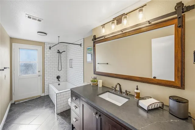 a bathroom with a sink vanity granite shower and a mirror