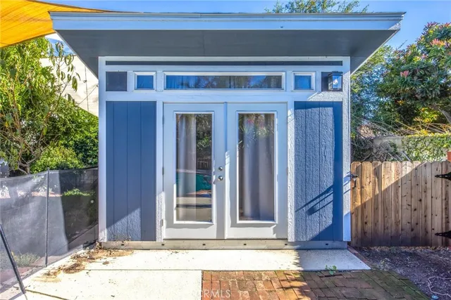 a backyard of a house with large trees and plants