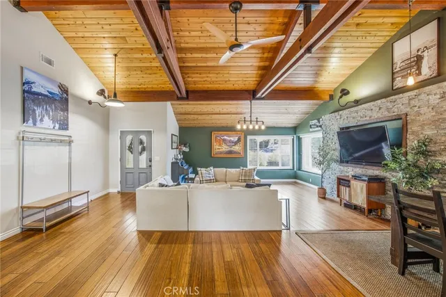 a living room with furniture a flat screen tv and a floor to ceiling window
