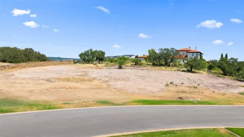 a view of a dry yard with trees