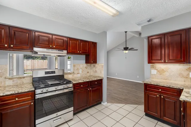 a kitchen with granite countertop a stove and a cabinets