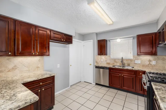 a kitchen with stainless steel appliances granite countertop a sink stove and cabinets