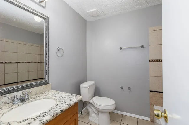 a bathroom with a granite countertop sink toilet and shower
