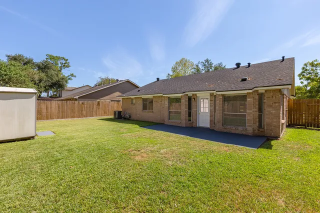 a front view of house with yard and trees in the background