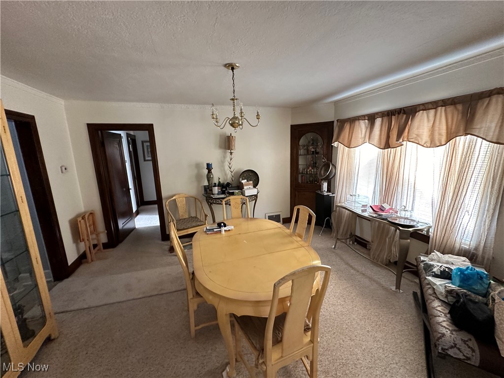 18007 Neff Road Cleveland, OH 44119 - Photo 8 of 29 Carpeted dining space with a textured ceiling and a chandelier