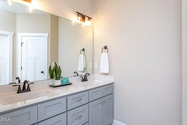 a bathroom with a double vanity sink and a mirror