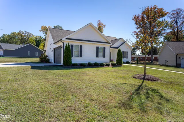 a view of a house with a yard and tree s