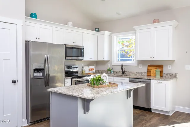 a kitchen with granite countertop a sink stove and refrigerator