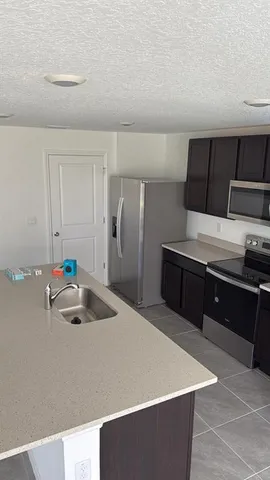 a kitchen with kitchen island cabinets and refrigerator