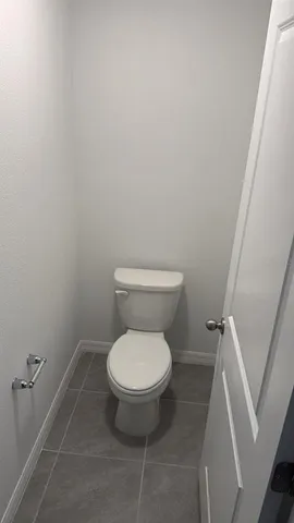 a white toilet sitting next to a shower