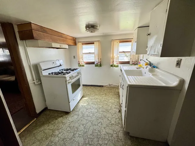 a kitchen with a sink stove and refrigerator