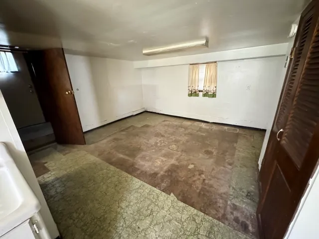 a view of a big room with wooden floor and windows