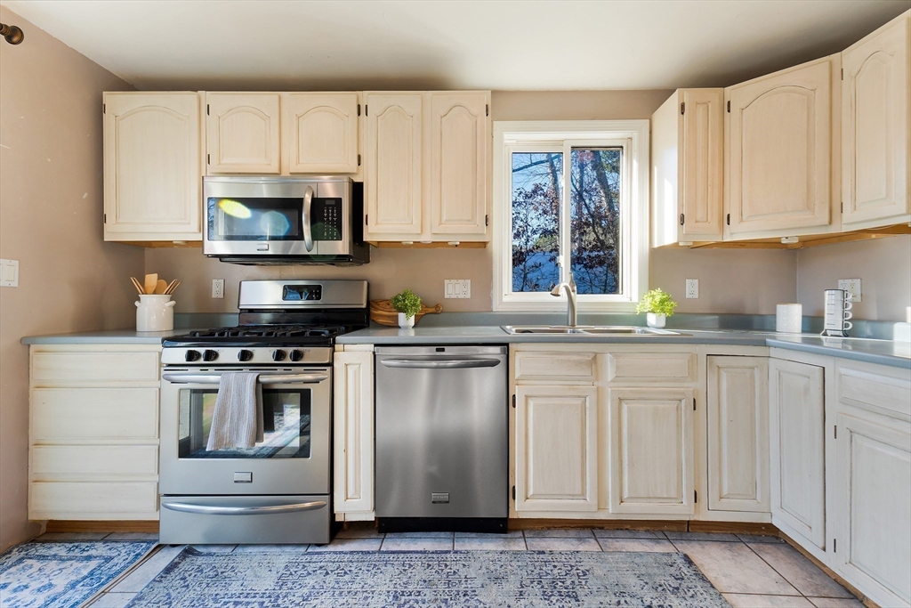 3 Riverside Road Billerica, MA 01821 - Photo 8 of 42 a kitchen with stainless steel appliances granite countertop a refrigerator stove and white cabinets