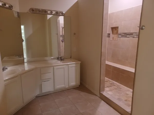 a bathroom with a granite countertop sink mirror and shower