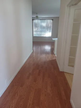 a view of a small space with wooden floor and a window