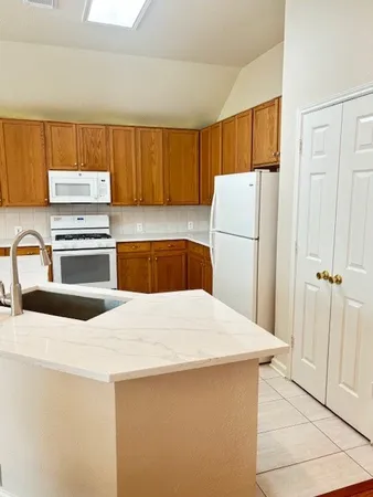 a kitchen with a refrigerator a stove and a sink