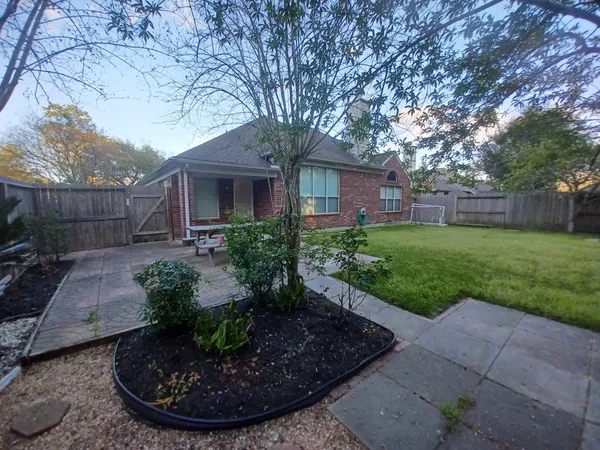 a view of a backyard with potted plants and large trees