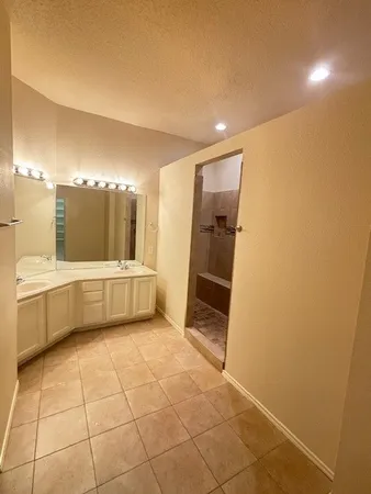 a bathroom with a tub a mirror and a sink