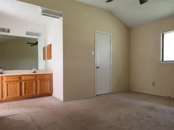 a view of an empty room with window and cabinet