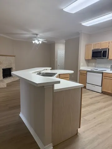 a kitchen with stainless steel appliances granite countertop a sink a stove and oven with wooden floor