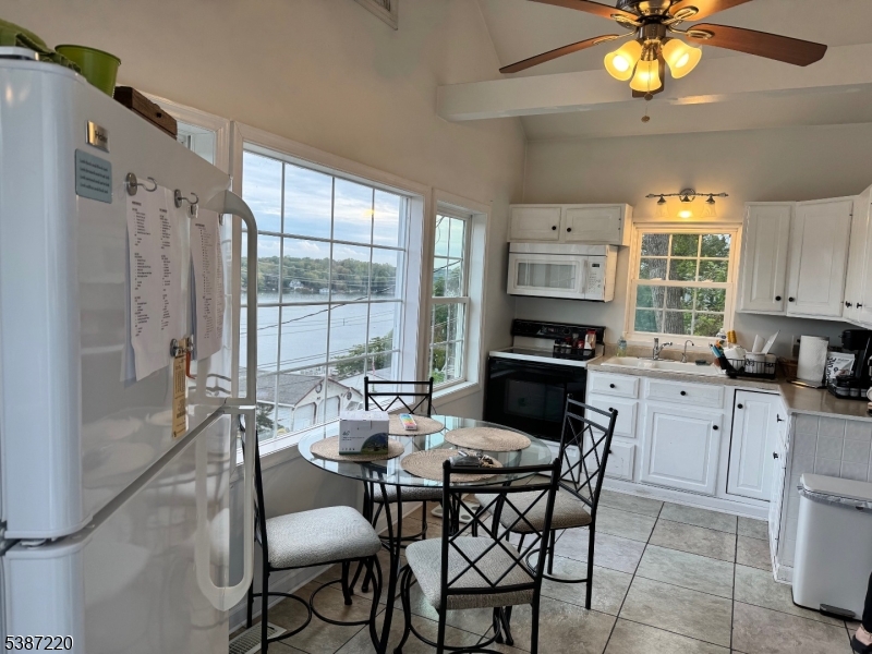 8 Hopatcong Street Hopatcong, NJ 07821 - Photo 11 of 22 a kitchen with a dining table chairs and a chandelier