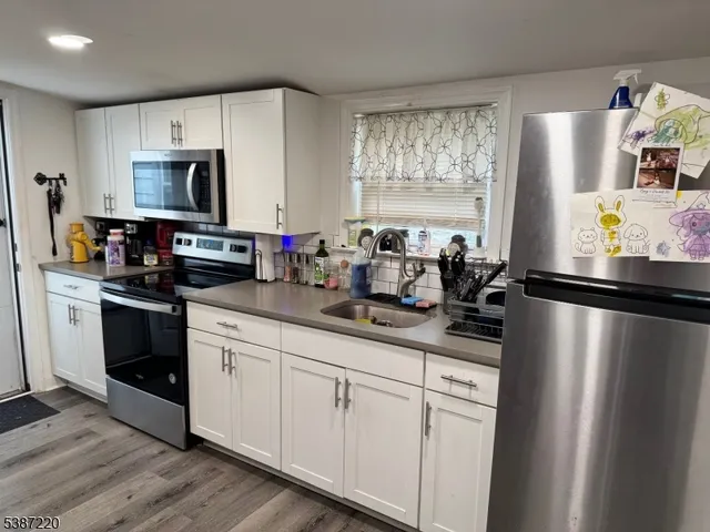 a kitchen with stainless steel appliances a sink stove refrigerator and cabinets